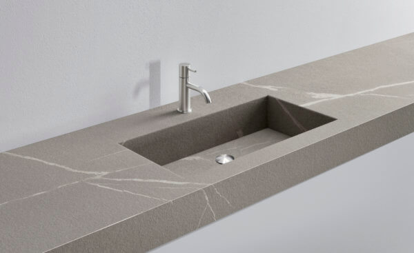 Contemporary stone kitchen sink and countertop with sleek design.