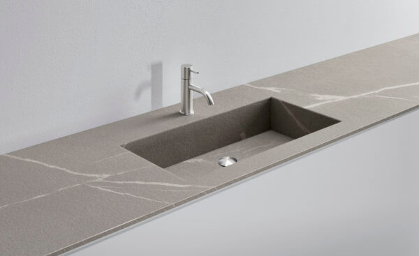 Gray stone kitchen sink with modern faucet and sleek countertop design.