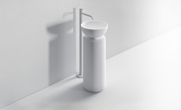 Lavabo minimalista bianco con supporto cilindrico e rubinetto a parete.
