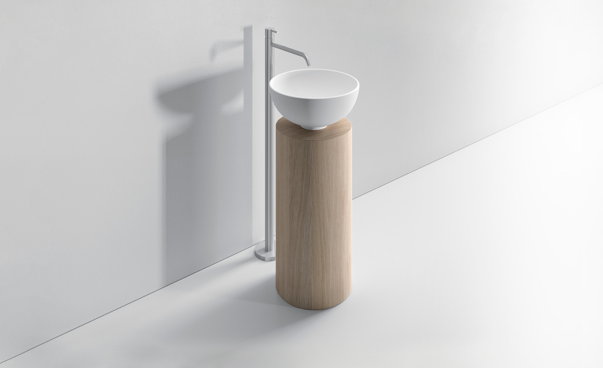 Lavabo bianco rotondo su supporto in legno naturale.