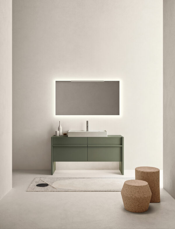 Minimalist bathroom with green vanity, backlit mirror, and cork stools.