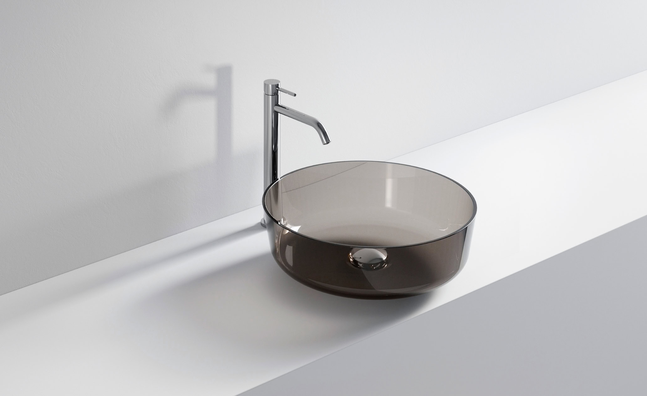 Lavabo rotondo in vetro scuro con rubinetto in acciaio inox.