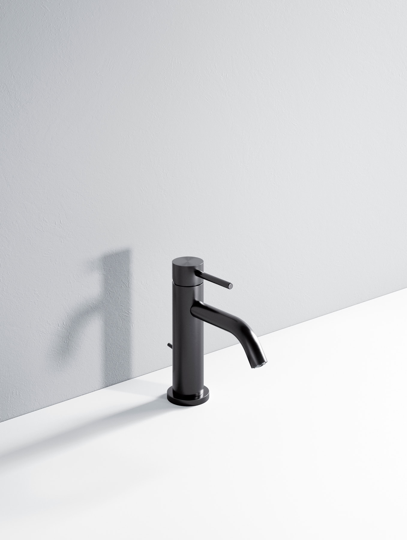 Rubinetto nero minimalista su superficie bianca con ombra sulla parete.