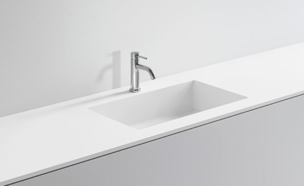 Lavabo bianco con rubinetto in acciaio inox su superficie bianca.