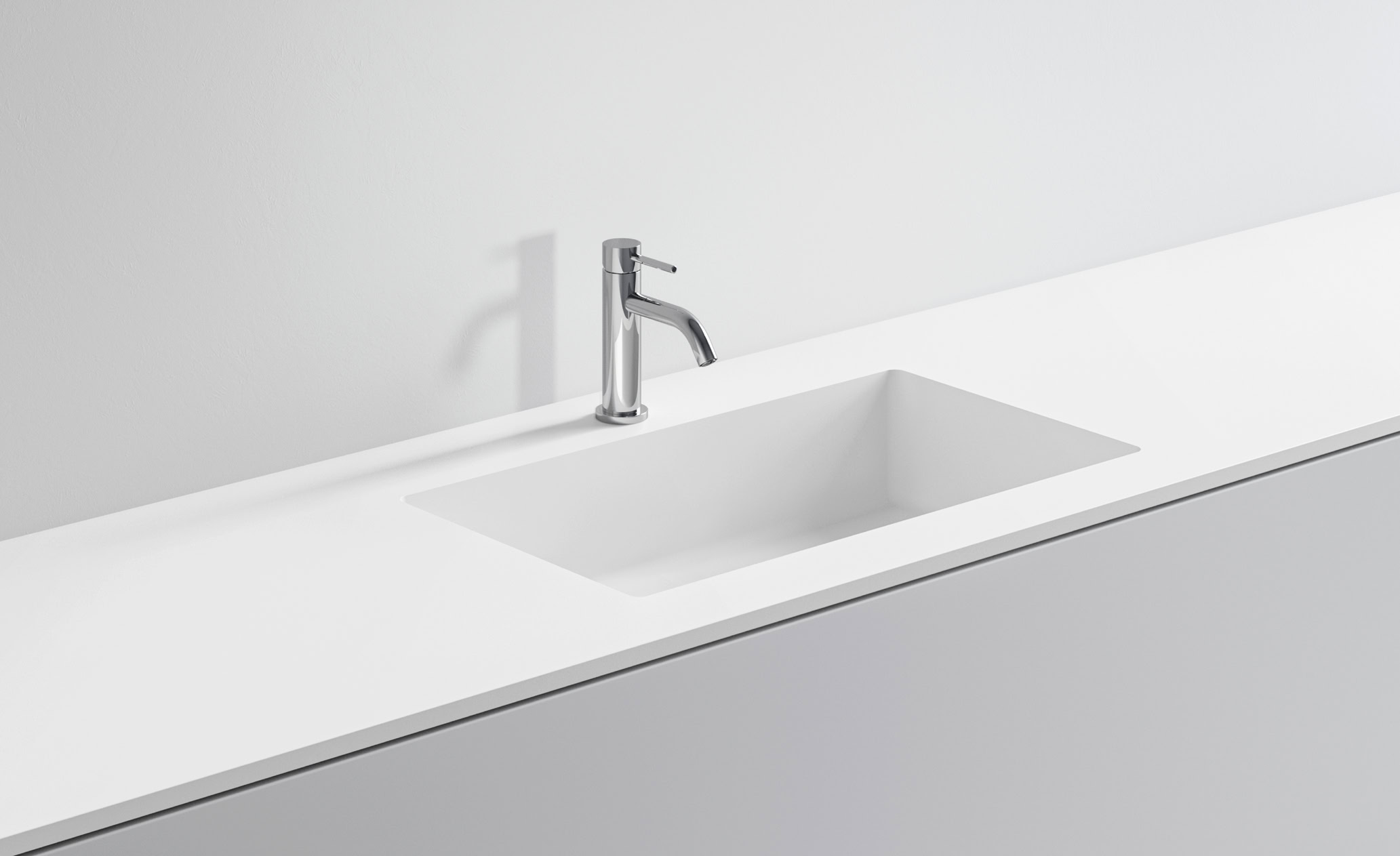 Lavabo bianco con rubinetto in acciaio inox su superficie bianca.
