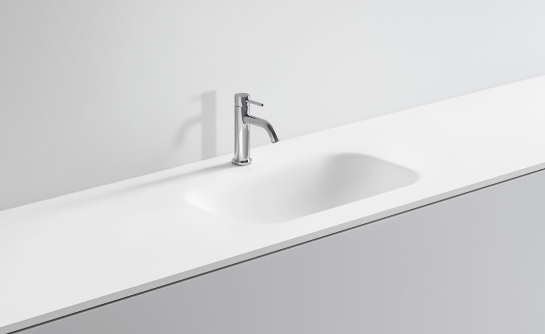 Lavandino bianco con rubinetto in acciaio inox in bagno minimalista.