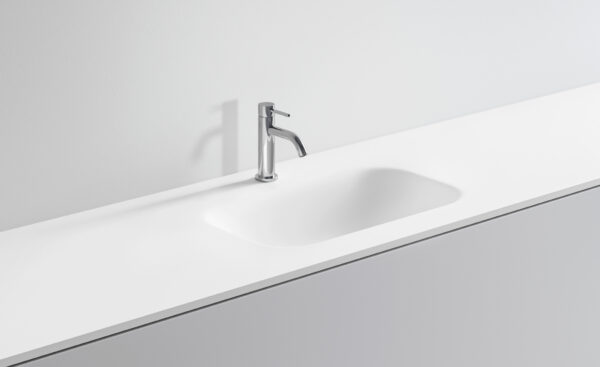 Lavandino bianco con rubinetto in acciaio inox in bagno minimalista.