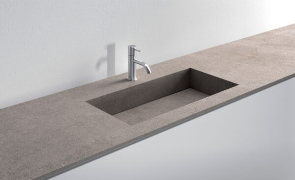 Lavello integrato in pietra naturale con rubinetto moderno.