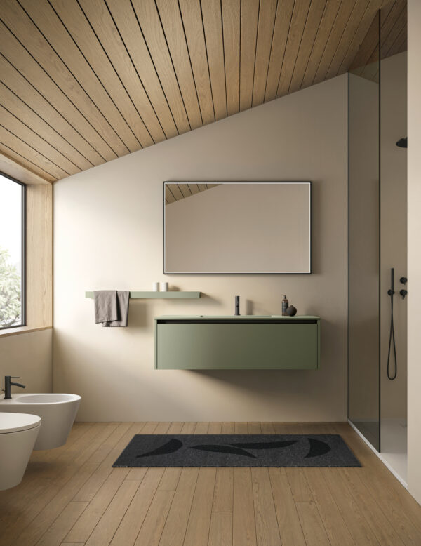 Bagno minimalista con specchio grande, lavabo verde e doccia a parete.