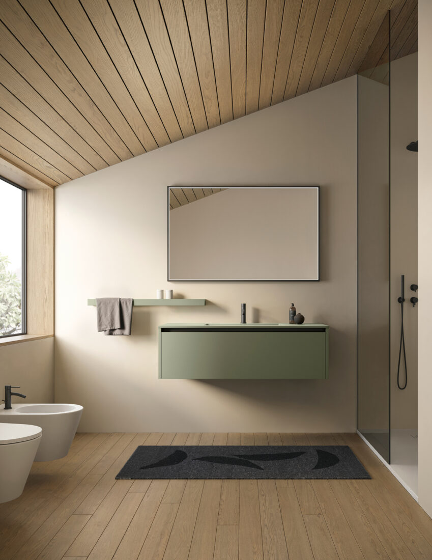 Bagno minimalista con specchio grande, lavabo verde e doccia a parete.