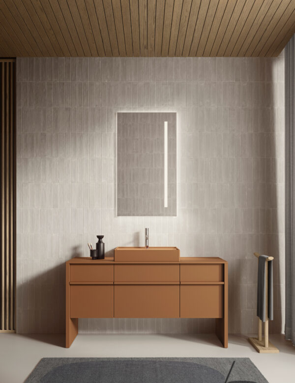 Arredo bagno minimalista con mobile in terracotta e specchio luminoso.