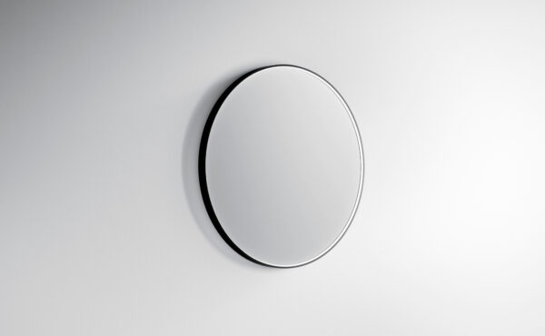Specchio rotondo minimalista su parete bianca moderna.