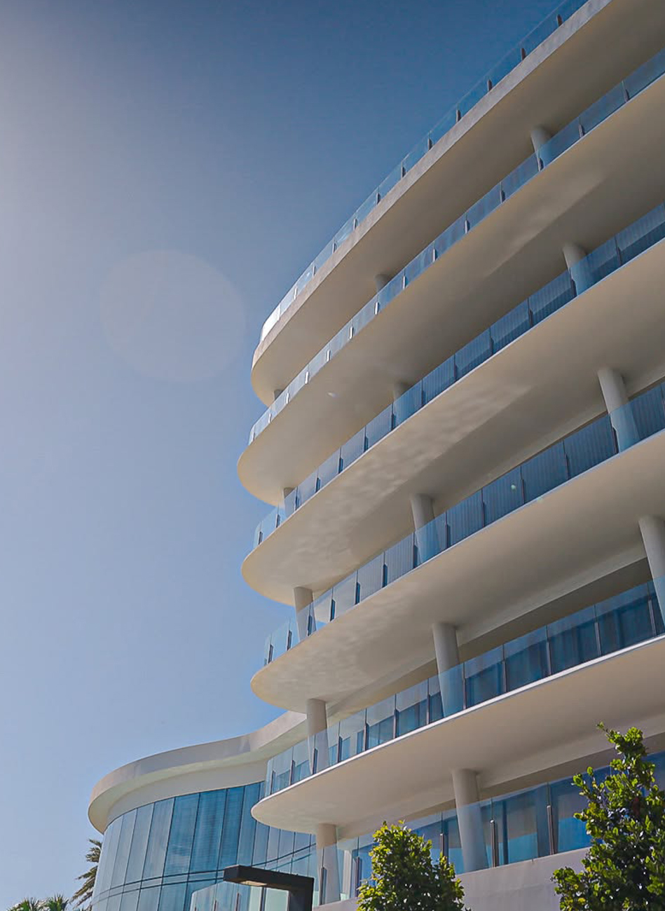 Edificio moderno a più piani con balconi curvi e vetri blu.