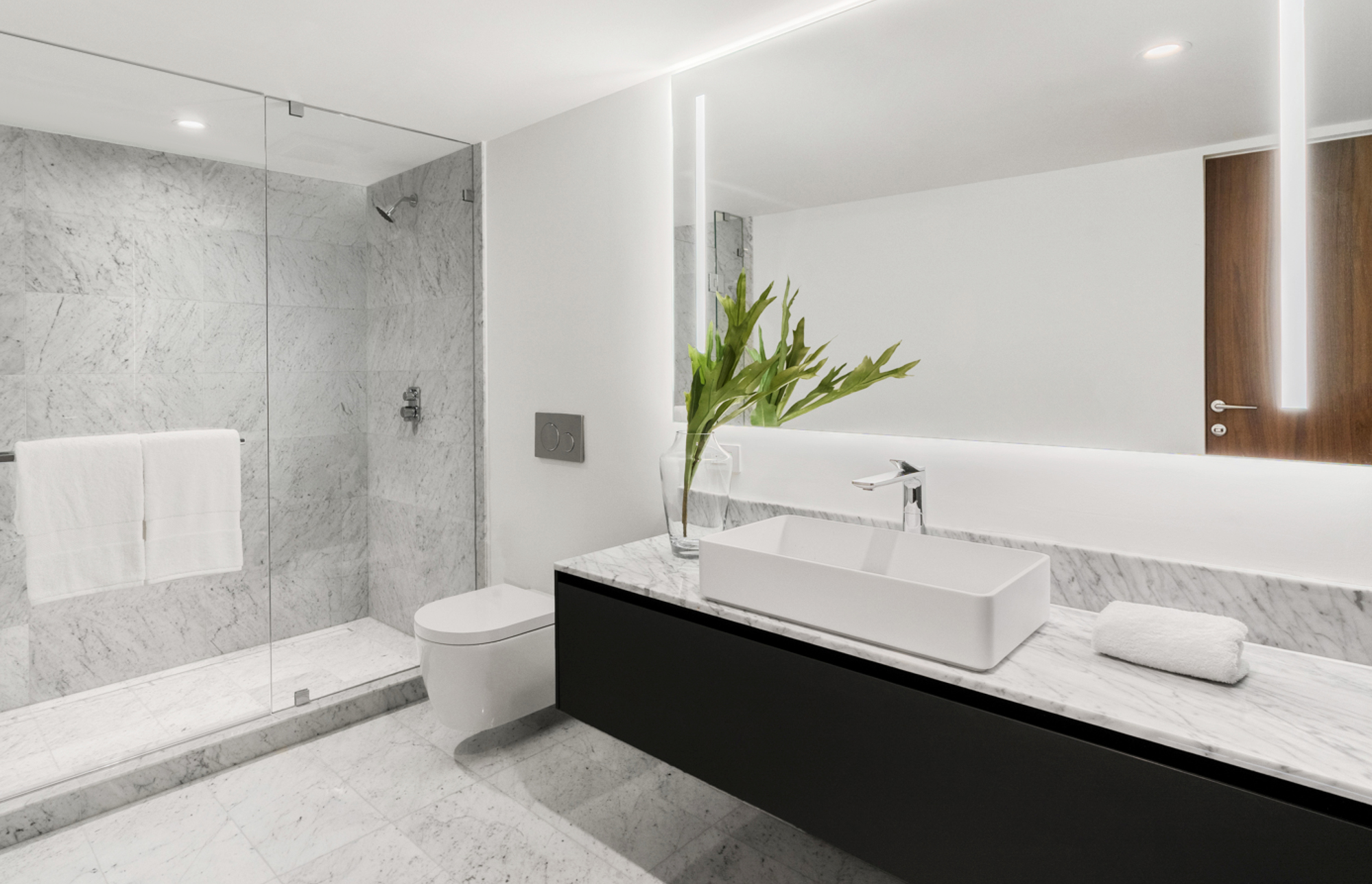 Bagno contemporaneo con doccia a parete e vanità nera.