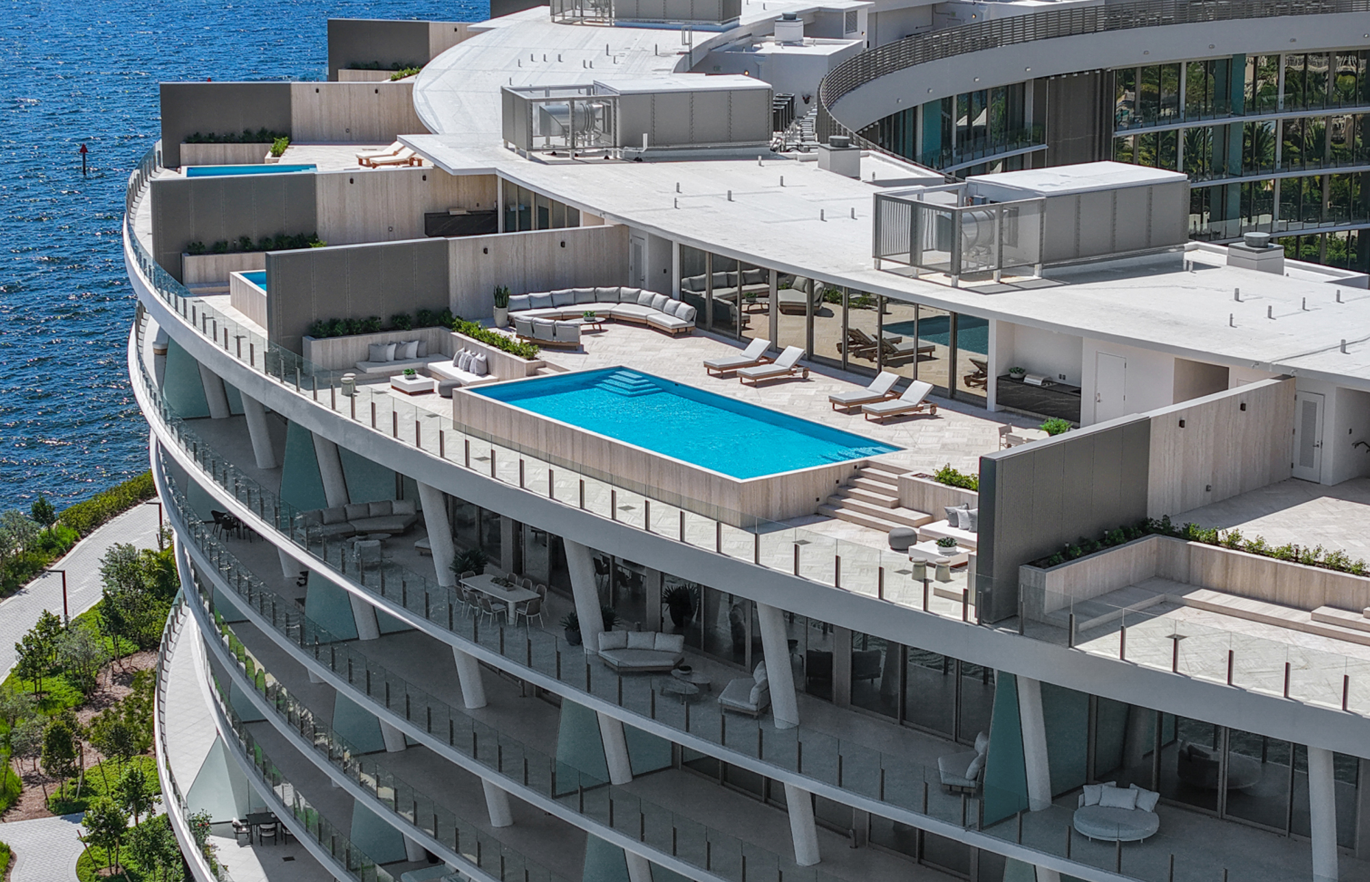 Piscina a bordo balconata con vista sul mare e architettura circolare moderna.