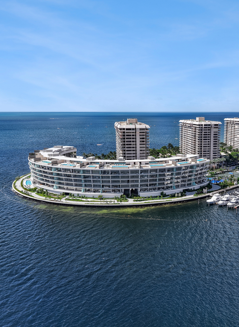 Complesso residenziale fronte mare su un'isola artificiale, moderno edificio curvilineo.